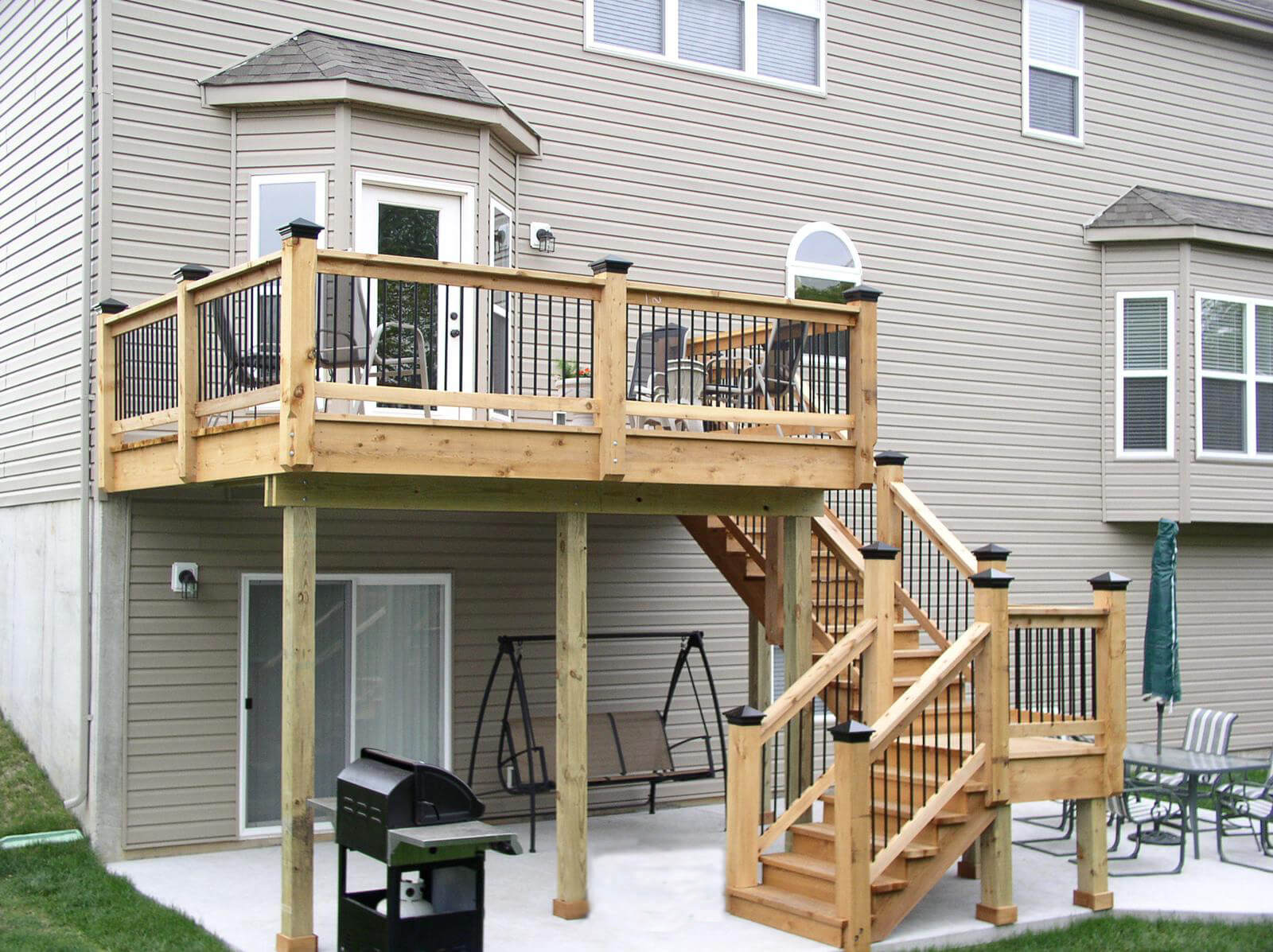 wood staircase leading to elevated deck on back of home